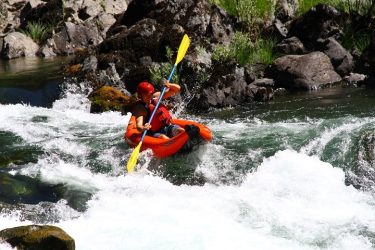 man on a kayak navigating through a white river
