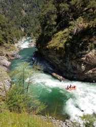 Above view of Trinity River with raft full of people on rapids