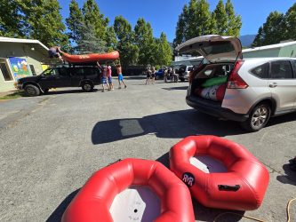 View of parking lot with people unloading river rafts